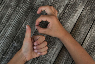 Cropped hands of child gesturing over wooden table