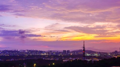 Illuminated buildings against sky during sunset