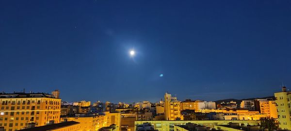 Buildings against blue sky at night