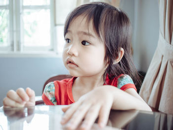 Close-up of cute girl sitting at table