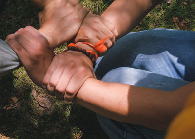 High angle view of people hands on land