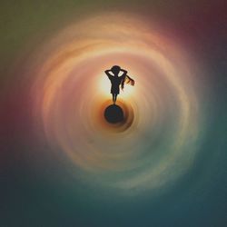 Silhouette bird flying against sky during sunset