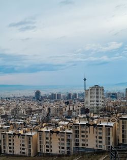 Buildings in city against cloudy sky