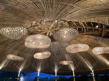 Low angle view of illuminated chandelier hanging on ceiling