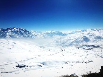 Scenic view of snowcapped mountains against clear blue sky