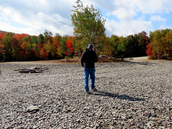Rear view of man standing on street during autumn