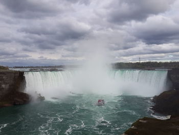 Niagara falls against cloudy sky