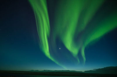 Green landscape against sky at night