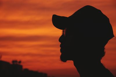 Silhouette man against orange sky