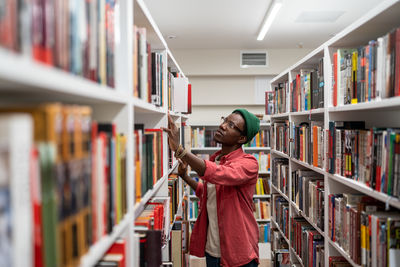 Side view of woman standing in library