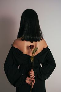 Rear view of woman standing against white background