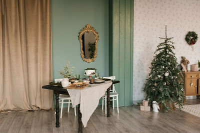 Beautifully laid table and christmas tree in the living room, decorated for the holiday