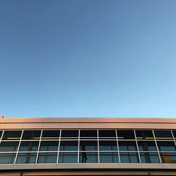 Low angle view of modern building against clear blue sky