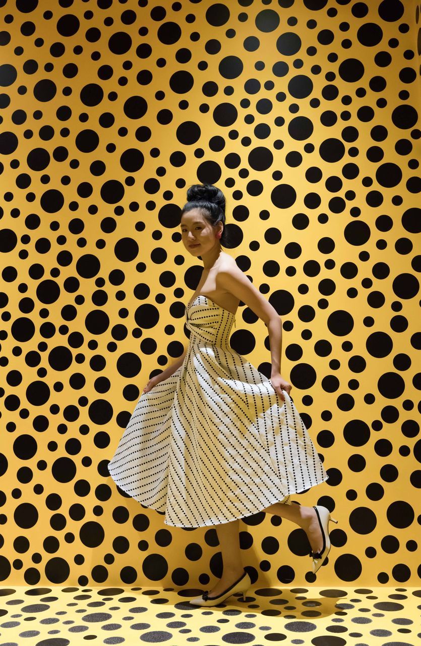 pattern, one person, full length, spotted, rear view, indoors, yellow, black color, real people, purse, day, young adult, adult, adults only, people