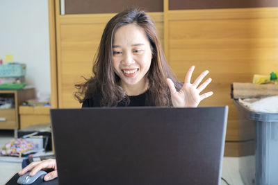 Portrait of smiling woman using phone at home