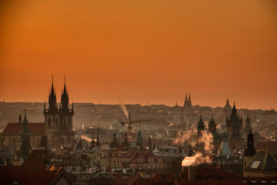 Prague silhouette at morning sunrise with red sky and chimney smoke