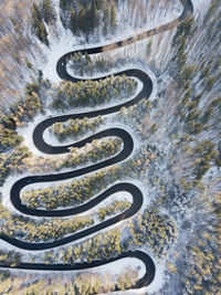 Winding road through the forest, from high mountain pass, winter