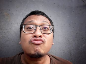 Portrait of smiling man against wall