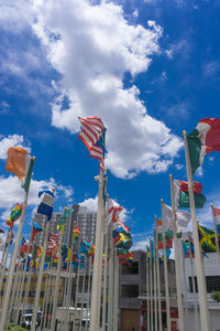 Low angle view of flags and buildings against sky