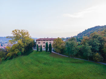 Built structure by trees against sky during autumn