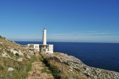 Lighthouse by sea against sky