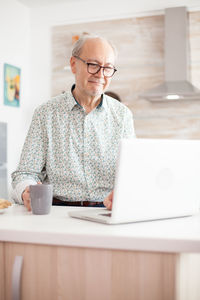 Senior man using laptop at home