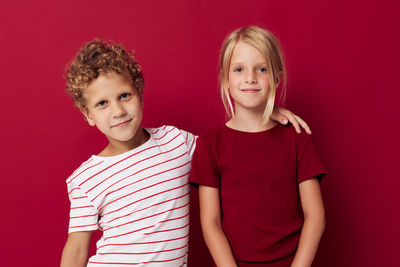 Portrait of happy friends standing against yellow background