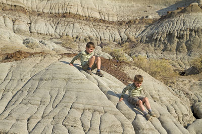 Boys playing on rock formation