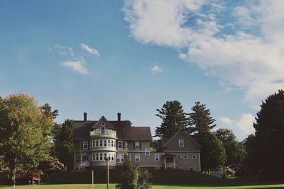 Low angle view of trees and buildings against sky