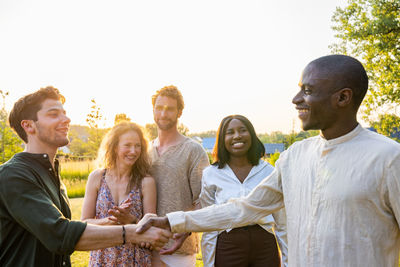 Portrait of smiling friends standing against white background