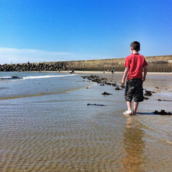 Full length of boy standing on beach