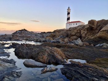 Scenic view of sea and rocks against sky during sunset