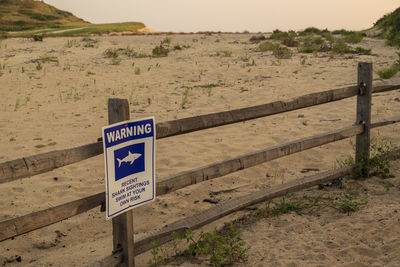 Shark warning sign on beach fence in truro, ma