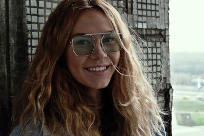 Portrait of smiling young woman wearing sunglasses