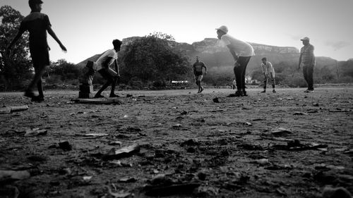 Low angle view of people playing on field against sky