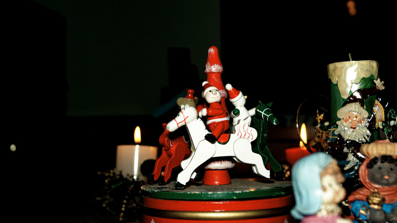 celebration, candle, representation, holiday, christmas, human representation, decoration, indoors, male likeness, tradition, no people, illuminated, religion, burning, belief, birthday cake, santa claus, christmas decoration, figurine, spirituality, event, table, sculpture, creativity, christmas tree, fire, craft, still life
