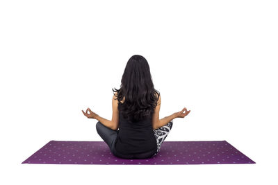 Low section of woman sitting against white background