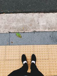 Low section of person standing on footpath