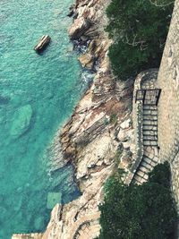 High angle view of stone wall by sea