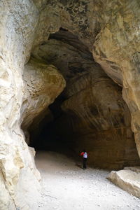 Rear view of man in cave