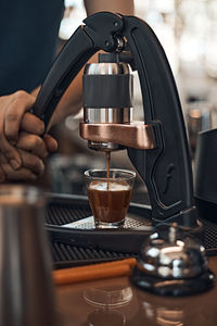 Close-up of hand pouring coffee in cup