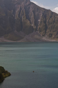 Scenic view of sea and mountains against sky