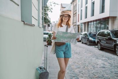 Portrait of young woman standing on street