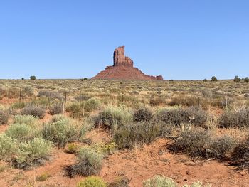 Built structure on landscape against clear blue sky