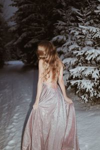 Rear view of woman standing by tree