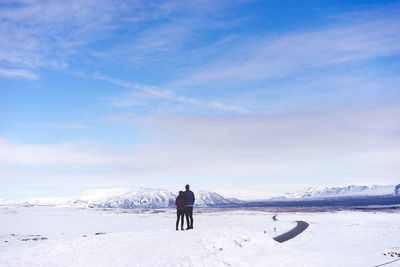 Couple standing on snow covered landscape