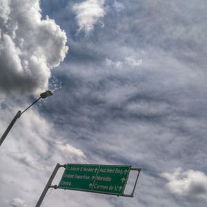 Low angle view of information sign against cloudy sky