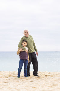 Little boy and his grandfather spending time on the beach