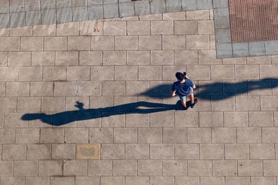 High angle view of man lying on footpath