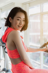 Portrait of smiling young woman exercising in gym